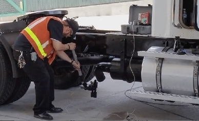 Technician attaching a a smoke meter to the exhaust pipe of a diesel truck