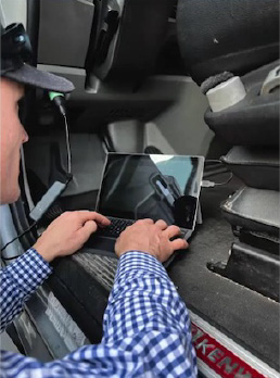 Technician using a laptop computer to OBD Test a Truck